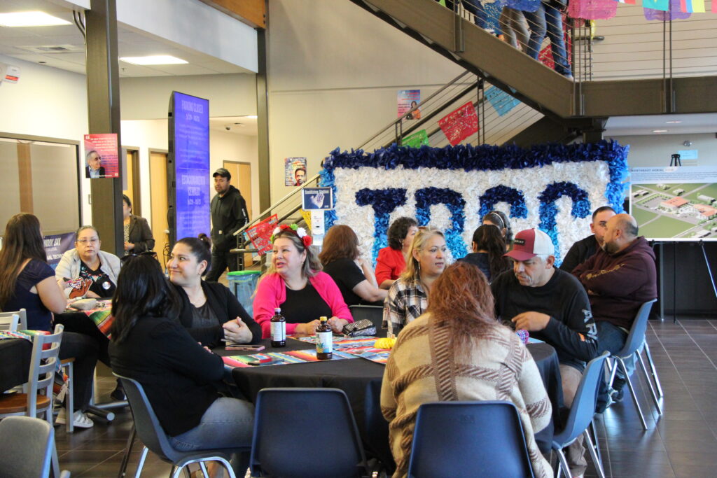 People gathered at round tables chatting in a decorated lobby